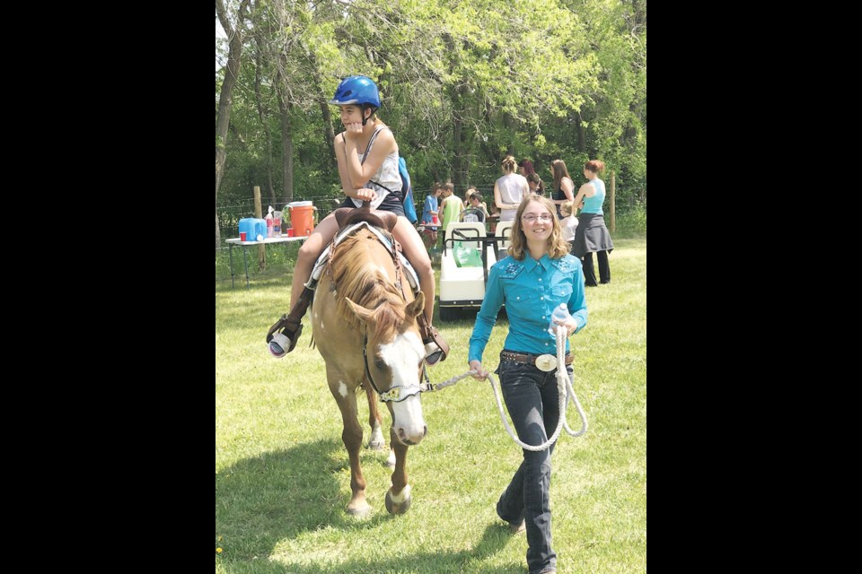 Ashley Kerslake leads a young rider aboard Jackson during the grand opening of the Prairie Crocus Equine Centre southeast of Lampman. Photo submitted