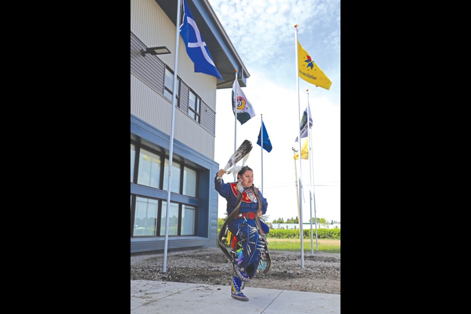 A dancer from the Dancing Horse Dance Troupe performs in front of the Métis nation, Muskowekan First Nation, Day Star First Nation, George Gordon First Nation, Fishing Lake First Nation and reconciliation flags. The flags were raised earlier in a ceremony in front of the Horizon School Division’s central office on June 21, national Indigenous peoples day. Photo by Devan C. Tasa