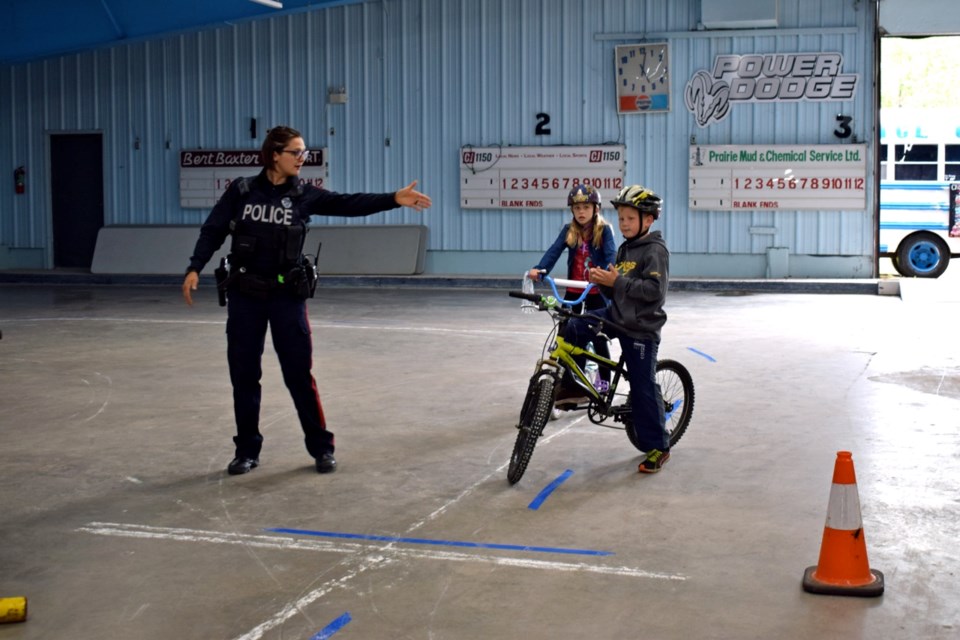 Constable Michelle Beaulieu was explaining to young riders the rules of going through a stop sign and signaling when turning. Photo by Anastasiia Bykhovskaia