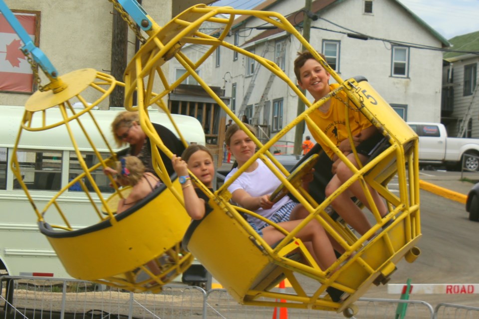 Lydia Alexander, Cassidy Alexander and Bobby Smith ride the Cyclone during the Main Street Days midway. - PHOTO BY ERIC WESTHAVER