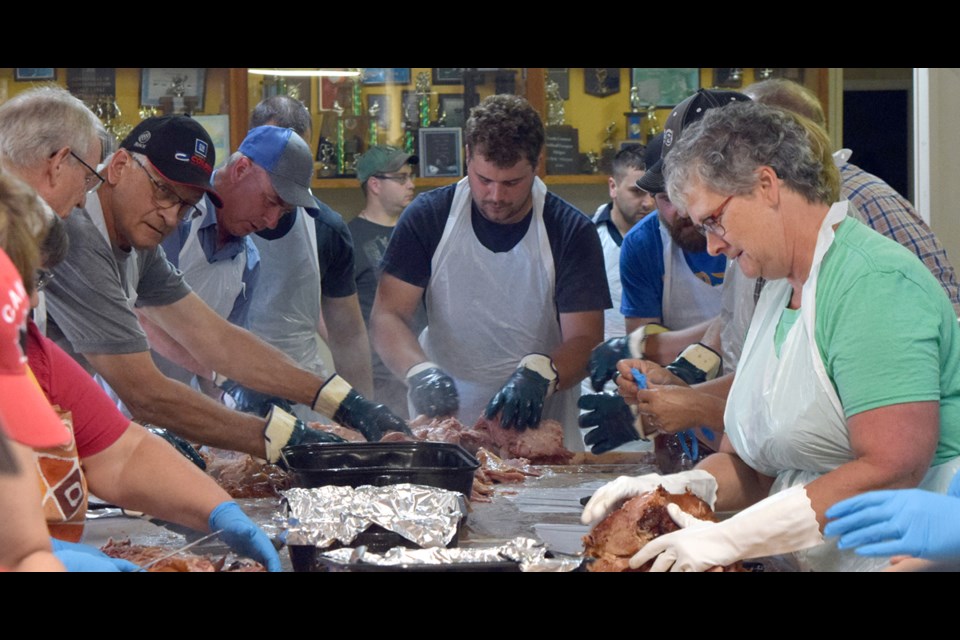 Volunteers fix the first pig from the roast at Englefeld's Hoghost on June 29. Photo by Kiernan Green.