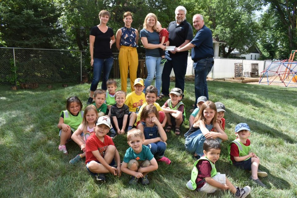 Robert Ritchie, right, an organizer of last year’s Smoke on the Water fundraiser, presented a cheque of $19,000 to the KamKids Daycare on Friday, which represents proceeds from the event. In the photo with several of the children being tended by the daycare, from left, were: Devin Hoots, assistant director of KamKids; Robyn Tataryn, the vice-chair; Chantel Kitchen, the chair, and James Turner, president of Innovative Outdoorsman Marketing Ltd., the organization which has taken over the staging of the annual fundraiser.
