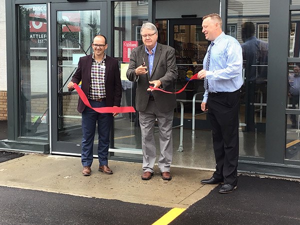 The ribbon cutting. Co-op board president Bryan Nylander cuts the ribbon flanked by Brett Sheppard, Discovery Co-op food division manager (left), and food store manager James Waggoner (right). Photo by John Cairns