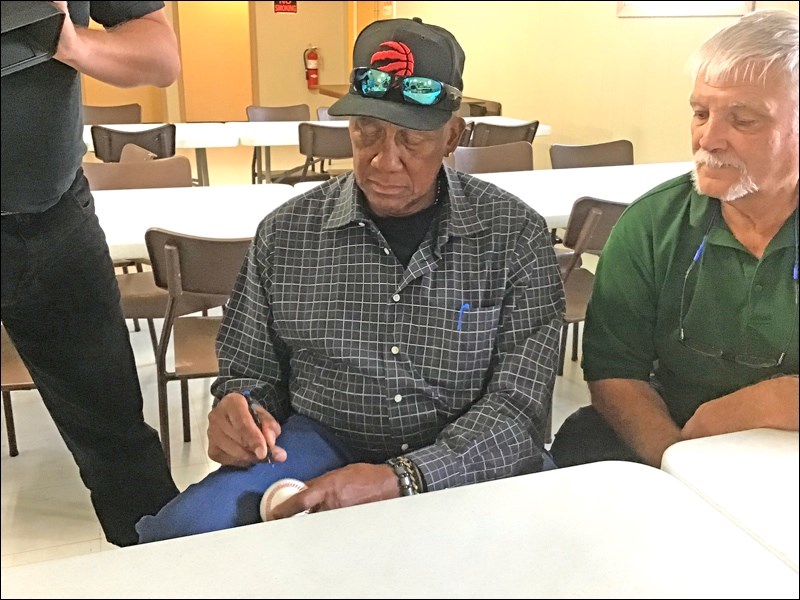 Ferguson Jenkins signs a baseball at the Legion Hall in Battleford during the lunch hour Saturday. H