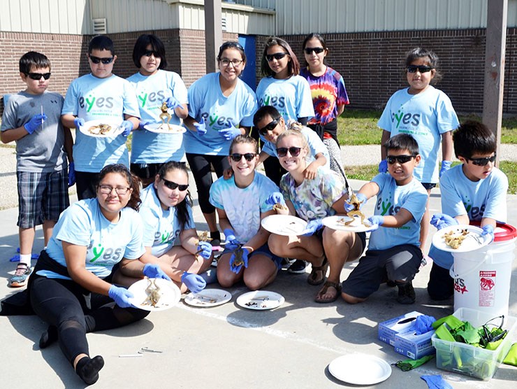 Students from Grade 1 to10 had the opportunity to take part in EYES Camp at the White Bear First Nation, thanks to a grant from inSTEM. Here the students proudly display the frogs they were dissecting during the biology section of the camp.