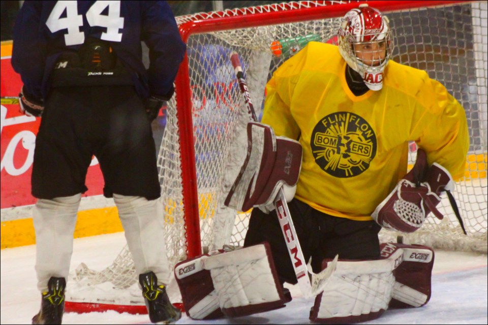 Wyatt Gelinas skates past goalie Jacob Delorme after Delorme freezes the puck. The only returning goalie from last year’s Bomber team, Delorme enters the season as the team’s presumptive opening night starter. - PHOTO BY ERIC WESTHAVER