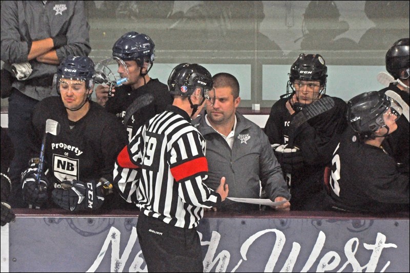 Head coach Brayden Klimosko chats with a referee prior to puck drop.