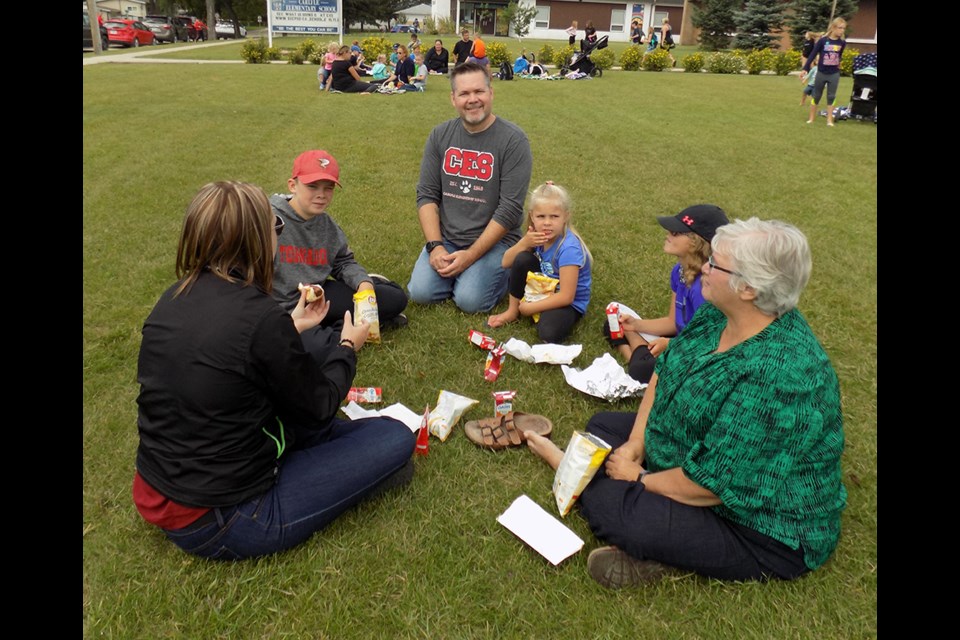 On Friday, Aug. 30 Carlyle Elementary School held its annual “Back to School” barbecue. Staff, students and family members gathered on the front lawn at CES and enjoyed a barbecue lunch. After lunch students could get introduced to their new teachers and classrooms for the upcoming school year. Here, CES principal Tyler Fehrenbach (centre) is enjoying the lunch and welcoming students back.