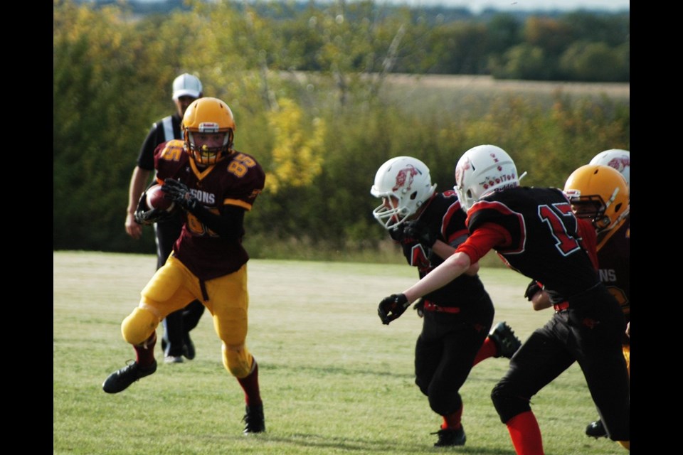 LCBI quarterback #85 Paul Haugen evades tackle attempts by the Hanley Sabers.