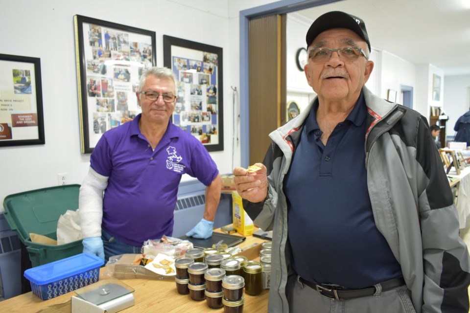 Sam Boychuk of Maple Creek, who was in the area visiting with his daughter at Madge Lake, stopped in at the Legion on September 8 to check out the displays at the Hint of Garlic Festival, and stopped to chat with Alfredo Converso, left back, and sampled some garlic jelly on a cracker.