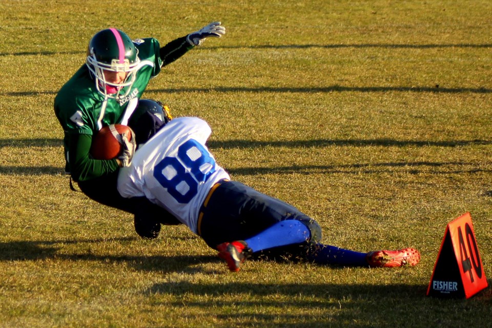 Kodiaks running back Evan Madarash is tackled by Sandy Bay defender Marcus McDonald in the second half of the Sandy Bay-Creighton playoff game Oct. 10. Creighton’s win will send them to Prince Albert to face the reigning champions, the Cumberland House Islanders. - PHOTO BY ERIC WESTHAVER