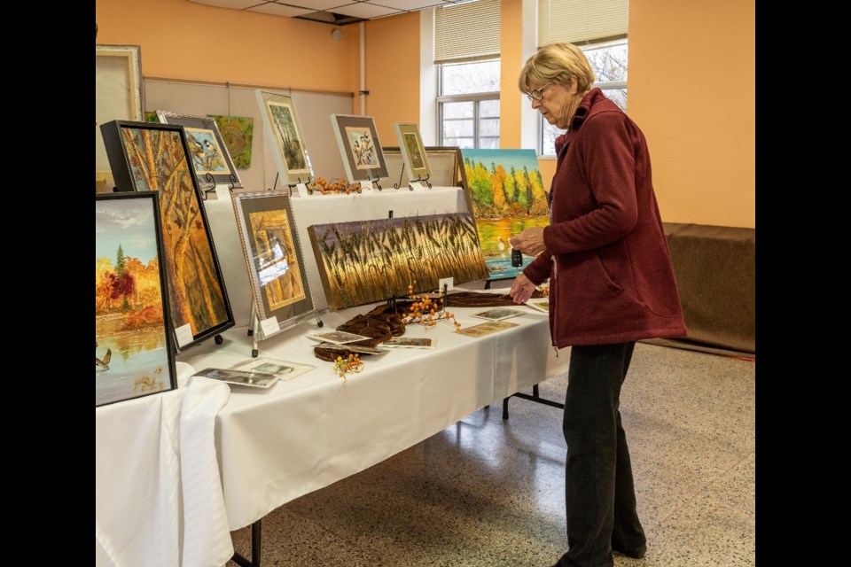 A shopper checks out Artic Visions art works.by Grace Gerein.