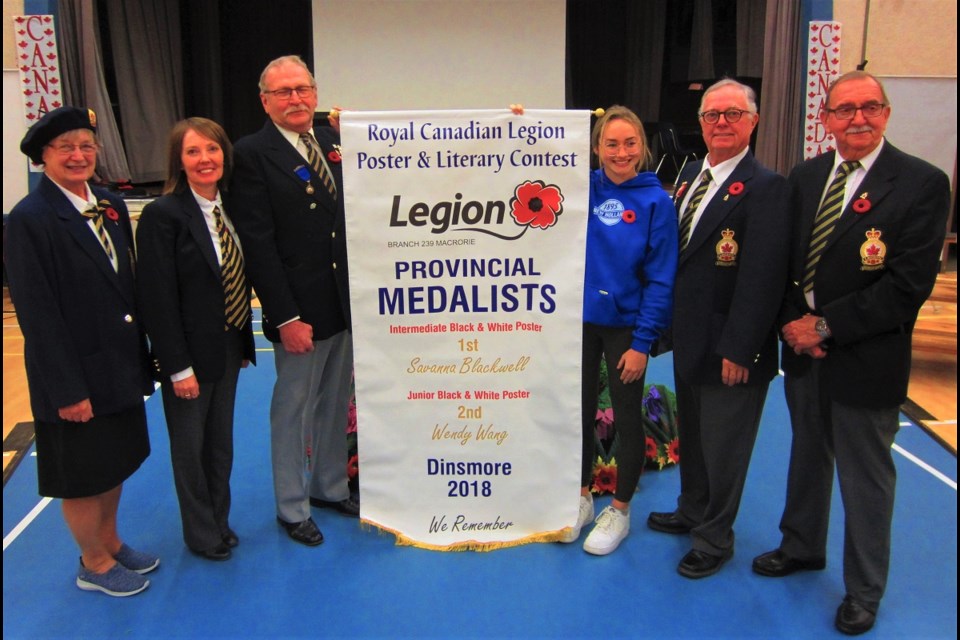 Noreen Andrew, Jade Ballek, Mike Perry, Dean Corbett and Harold Aitchison of the Macrorie Legion Branch #239 pose with Dinsmore student Savanna Blackwell after unveiling a special banner recognizing the efforts of her and fellow artist Wendy Wang.
