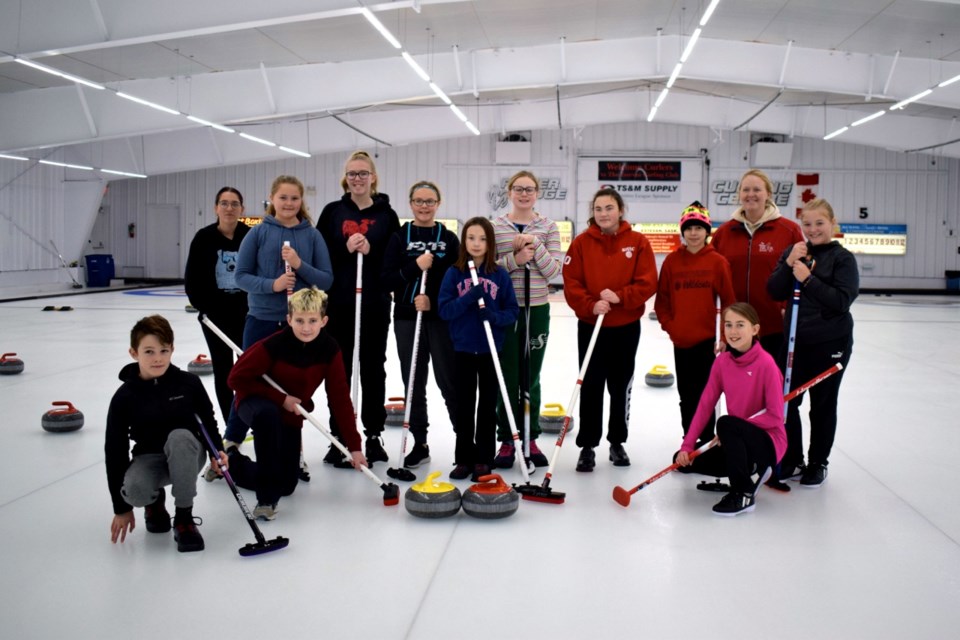 Andrea McEwen, second from the right, taught youths basic curling skills. Photo by Anastasiia Bykhovskaia
