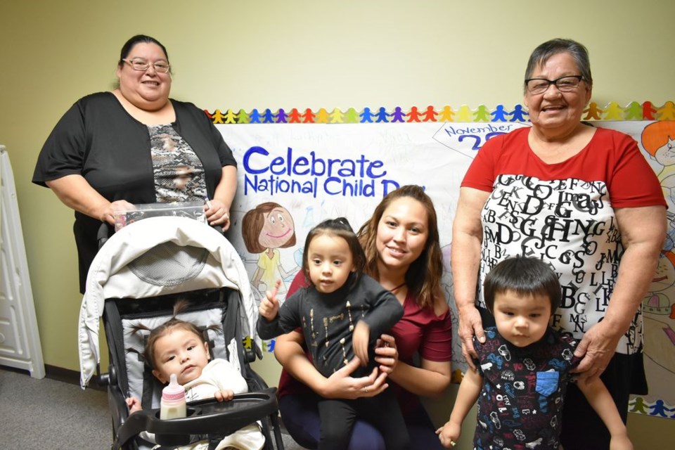 From left (back), Monica Perswain (director) and Marilyn Whitehawk (toddler caregiver) and (front) Vada (in stroller), Raylene Stevenson (infant caregiver) holding Laikyn and Daniel, all of the Wild Pigeon Daycare at Cote First Nation (FN) helped celebrate National Child Day at the Family Resource Centre in the Crowstand Centre on November 20.