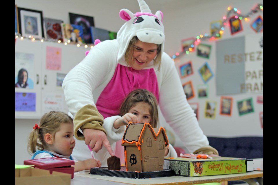 Suzanne Peters helps Kenzie Peters build a graham cracker haunted house during Hapnot’s first Café Français event this year Oct. 30.