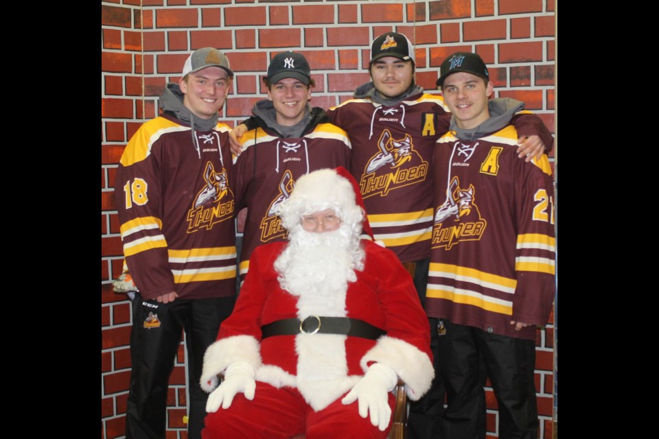 Outback Thunder players Tyrell Nicklen, Tristin Strunk, Brett Harper, David Wiens pose with Santa Claus, who appeared at the Carrot River United Church during the festivities. Photo by Jessica R. Durling