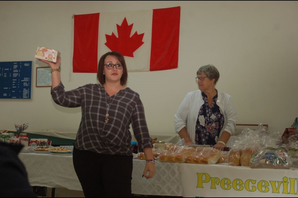 Stacey Strykowski, left, auctioned off the first item during the Preeceville Hospital Auxiliary Christmas on November 25. Darlene Medlang, an auxiliary member, assisted Strykowski.