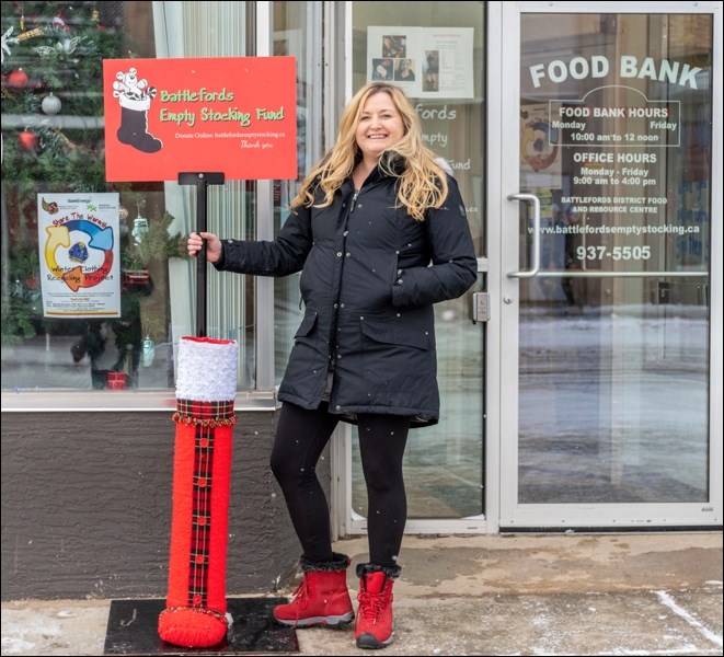 Erin Katerynych, executive director of the Empty Stocking Fund, shows off the newly updated boot you will see at various places throughout the city.