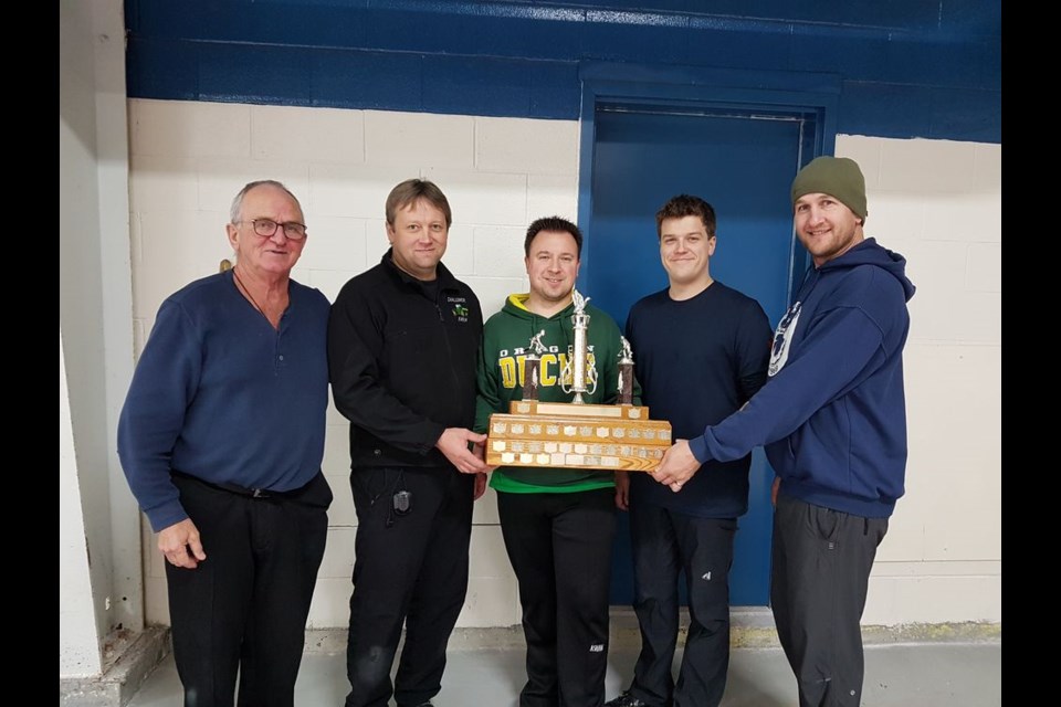 From left, Thomas Jordens, Duck Mountain Super League chief executive officer, presented the 2019-20 championship trophy to Norquay’s Ken Newell (skip), Evan Rostotski (third), Michael Maga (second) and Jason Lukey (lead). Photo by Ed Guenther.