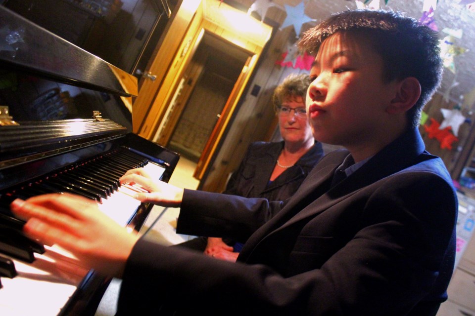 Owen Qiu’s fingers dance across the keys during a lesson with his teacher, Susan Fulford. One of Fulford’s brightest young pupils, Qiu plays with an energetic yet focused style. - PHOTO BY ERIC WESTHAVER