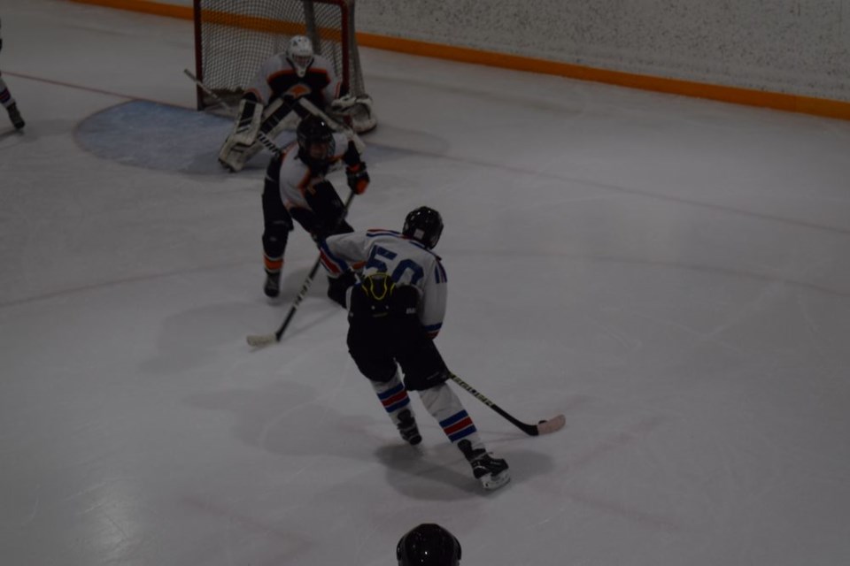 Logan Wolkowski of Canora, a member of the Pats bantam squad, using a Yorkton defender as a screen, ripped a dangerous shot on the Yorkton goal in a game that ended in a 4-4 tie
