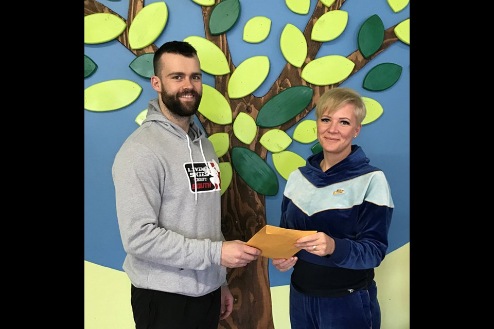 Carson Brady (left) of Living Skies CrossFit presents Colleen MacMillan, Executive Director of The Estevan Family Resource Centre, with a donation raised at the recent weight loss challenge. Michelle Walsh of Estevan was the top loser and her charity of choice was the Resource Centre.