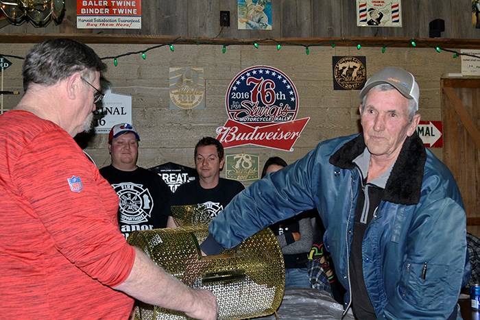 Russ Knowles (right) draws Shannon Knibbs’ name for the first chance at the Ace of Spades. Because Shannon was not in attendance, her proxy, Derek Big Eagle, drew the Five of Hearts and Shannon won $1,582.