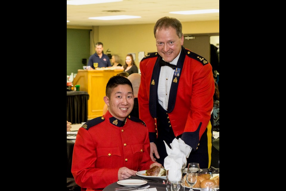 The most senior member, Commanding Officer of F Division Assistant Commissioner, Mark Fisher, serving the meal to most junior member, Cst Glenn WU, of the Estevan RCMP. Photo by Wanda Harron