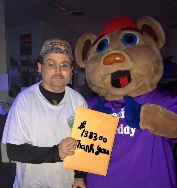 Edward Irvine was photographed with Telemiracle Teddy, holding a sign to indicate the amount of funds he raised for Telemiracle 44.