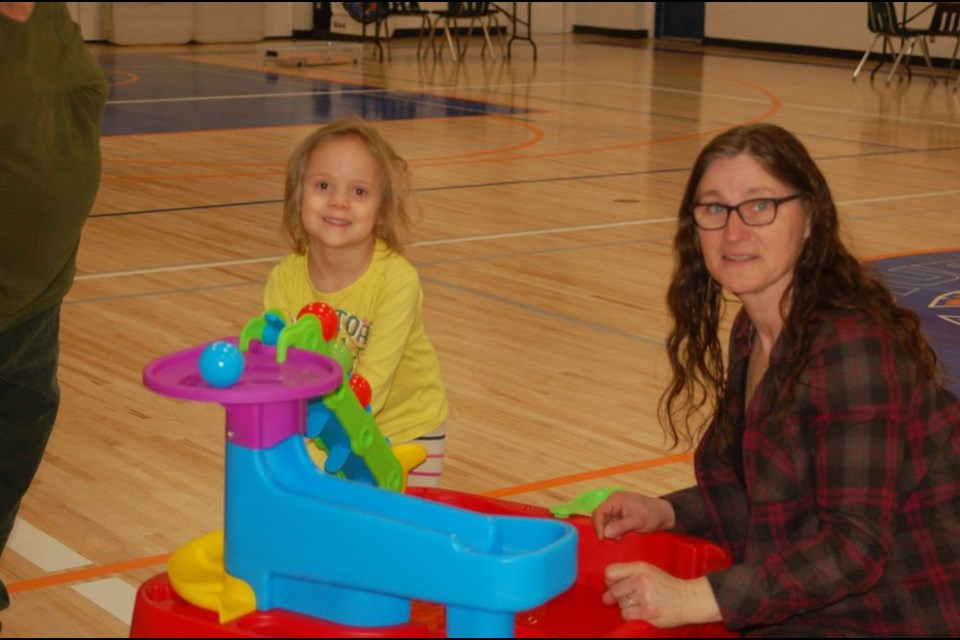 Karolyn Kosheluk, right, helped Cruz Jaeb with playing in the water station.