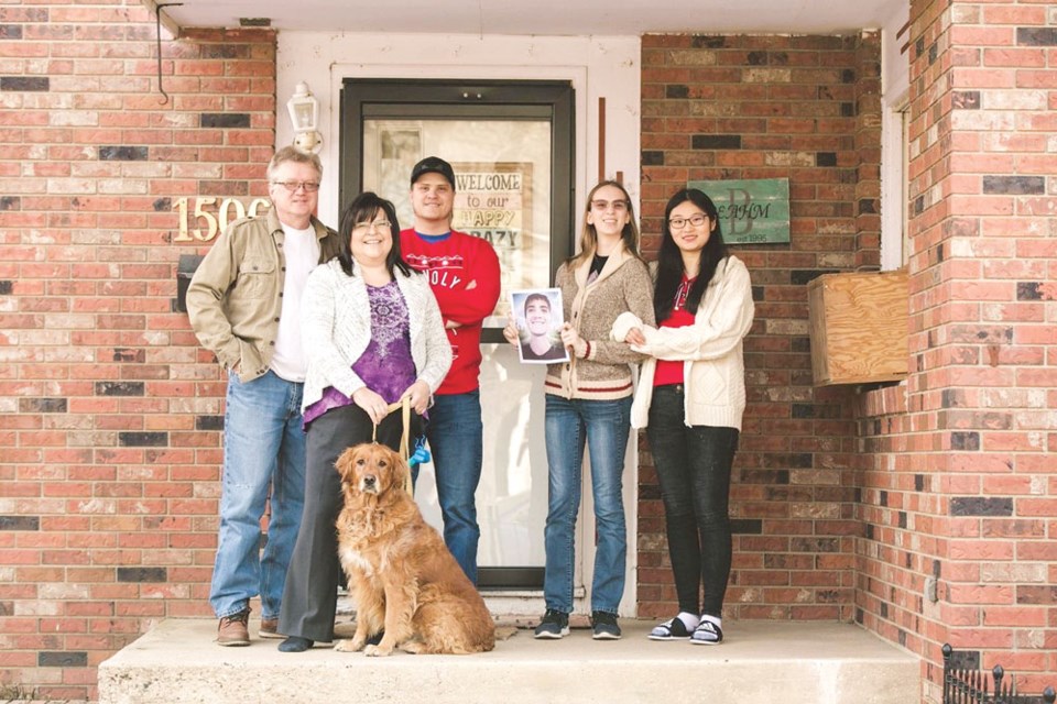 From left, Darwin Beahm, Dawn Marie Sloan-Beahm, Sam Beahm, Victoria Beahm and Xiao Dong with their dog Arya. Missing are Jesse Beahm and Zach Beahm. The photo was taken as part of the Front Step Project by Starr Mercer.
