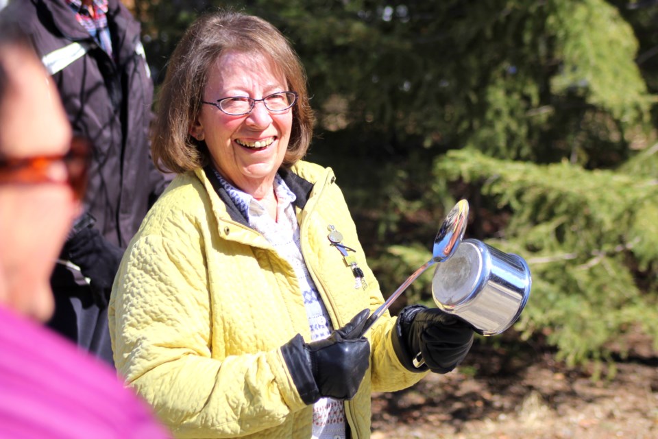 Lorna Heuchert bangs together a spoon and pot during a small ceremony at Blondie’s Beach May 10. Residents of the cottage subdivision have gathered each Sunday at noon while observing social distancing to celebrate first responders and emergency personnel working during the outbreak. - PHOTO BY ERIC WESTHAVER