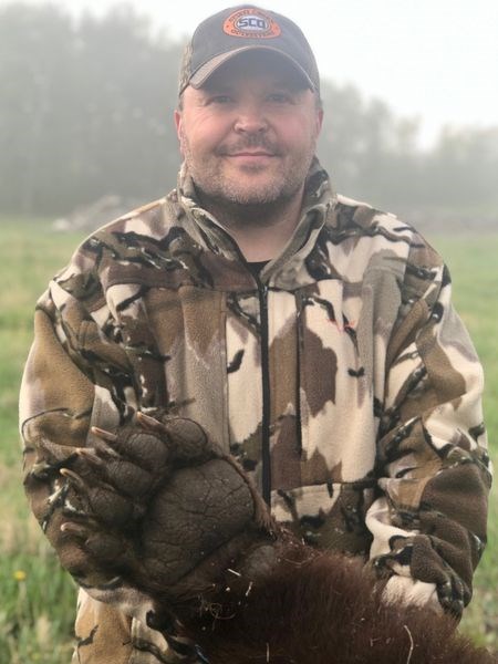 Blair Mitchell showed the large paws of this gigantic 530-pound bear that he shot southwest of Preeceville.