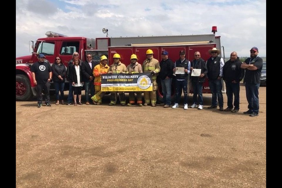 Members of the Cote FN Volunteer Fire Department held the banner which accompanied the Wildfire Community Preparedness Award which was presented to the Department on June 8.