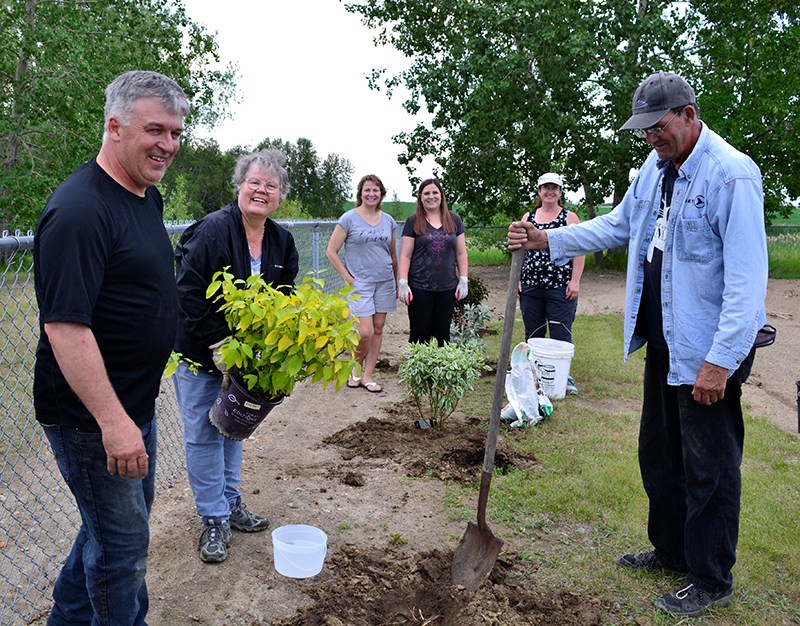 (L-R): Manor residents Claude Poirier, Lucille Dunn, Candy Bye, Korinn Riddell, Tory Poirier and Craig Savill all take turns on the shovel while tree planting at the Manor School.