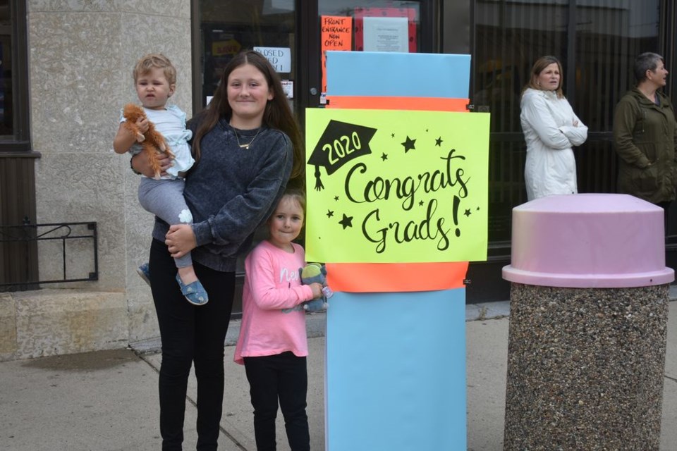 Among the area residents keen to cheer members of the KCI Class of 2020 who were about to participate in a parade through the community, from left, were: Eve Andrychuk, held by Ava Vidomski, and Ivy Andrychuk.