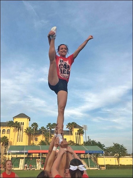 Caitlyn does a celebratory heel stretch on the lawn after performing at Cheerleading Worlds. Photo s