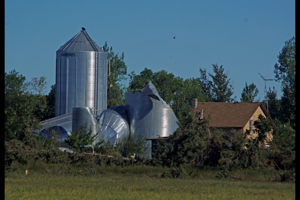 Giovanni Colangelo's yardsite, the scene of a tornado that ripped through the Scarth district, some 18 kms south of Virden, along Hwy 83; the home is still standing, with some damage. Damage appears throughout farm equipment.