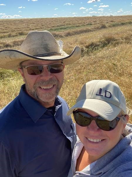Unity area farmers, Dan and Carrie Winterhalt, stand by their swathed crop as their harvest operations continue. They are optimistic at the potential their nice looking crops seem to be offering. Photo submitted