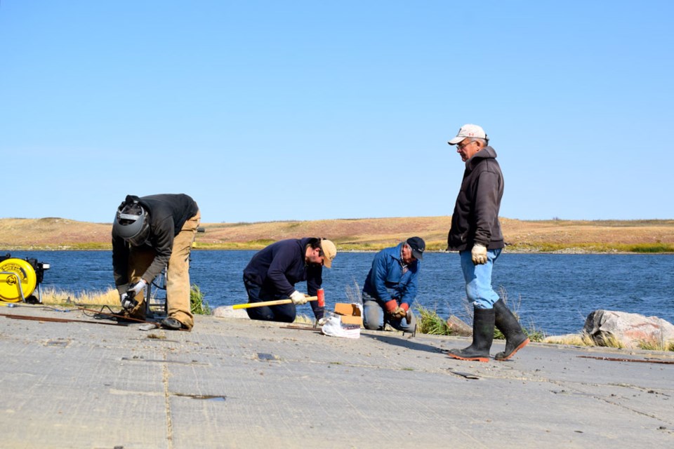 Volunteers Lance Marcotte, Jerry Seipp, Nathan and Barry Dies, along with Lonnie Barber and Barry Bod (missing from the picture), were working at the Rafferty boat launch Wednesday morning.