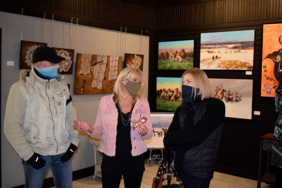 From left, Brian Fuhr, Theresa Fuhr and Melissa Schiestel discuss artwork during the House Artist Showcase.