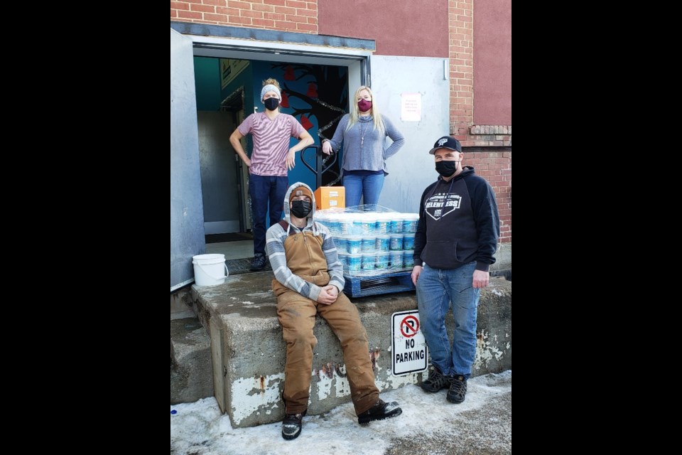 The Southgates deliver 450 containers of honey to Erin Katerynych and Warehouse Coordinator Kjell Graupe at the food bank. Photo submitted