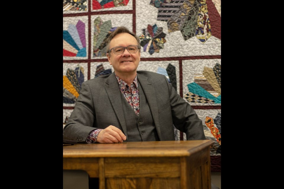Ben Christensen has virtually all of the ties he’s ever owned in the form of a giant quilt, seen as a backdrop to this photo, made by Irene Halco of Spiritwood, who, as Miss Lavoie, was Christensen’s Grade 3 teacher in 1963 when his family lived in Spiritwood.