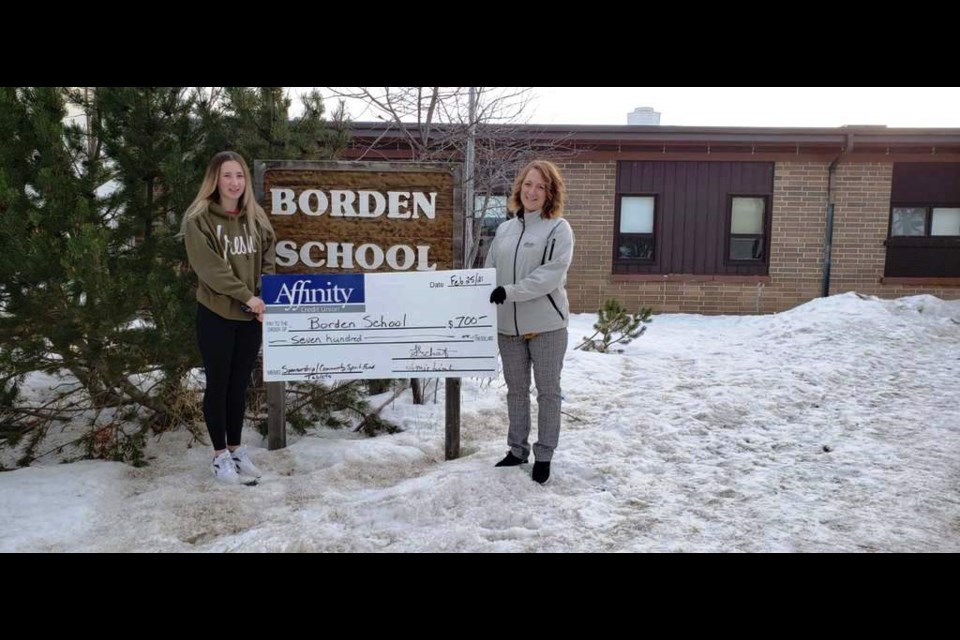 In late 2020 Affinity Credit Union gave the Borden School $500 toward the purchase of more Chromebooks and another Chromebook charging cart. Lynette Schmidt of Affinity (right) also gave her $200 employee community spirit fund to them as well. In this picture she is presenting to her daughter, who is a Grade 10 student in Borden.