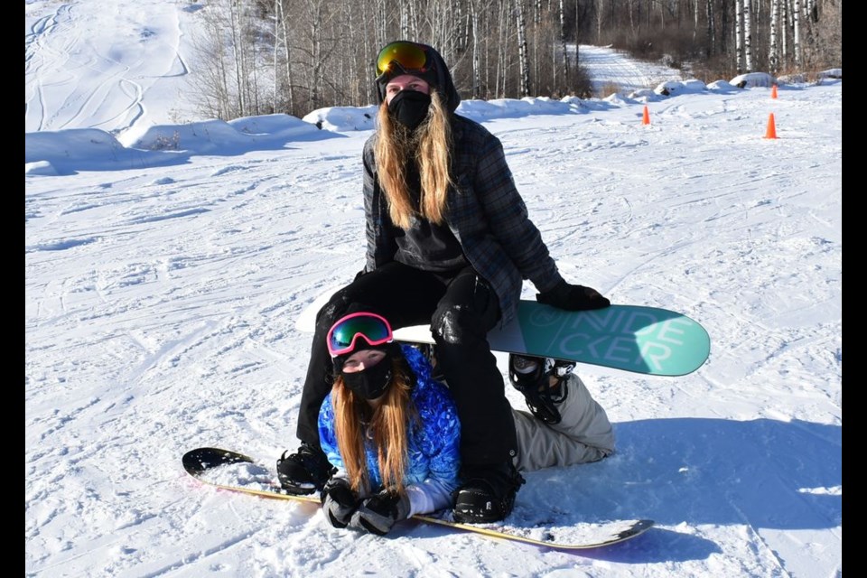 Staff members at the Duck Mountain Ski Area, Shaelyn David and Michaela MacKenzie are seen here modeling some of their Tik Tok inspired snowboarding moves.