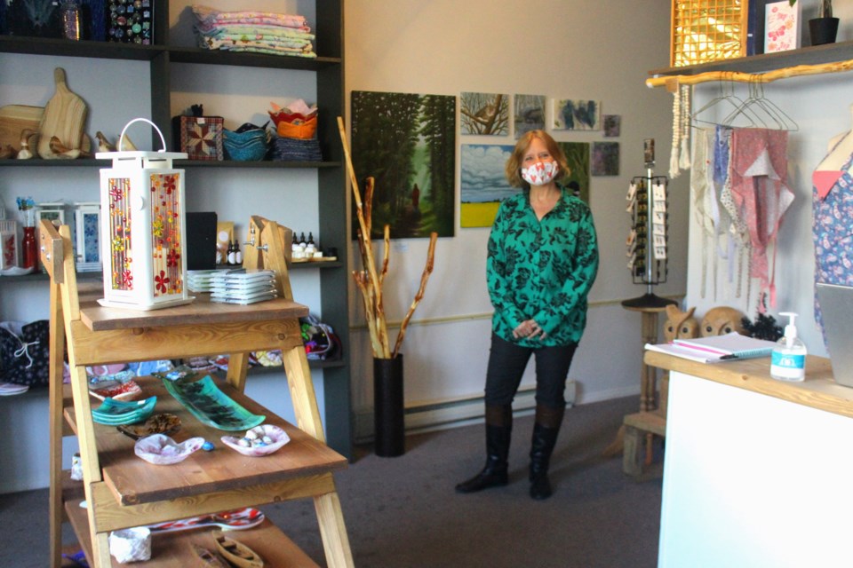 Flin Flon Arts Council cultural coordinator stands in the new location of the Uptown Emporium - the council’s local crafts and handiworks shop on Main Street. - PHOTO BY ERIC WESTHAVER