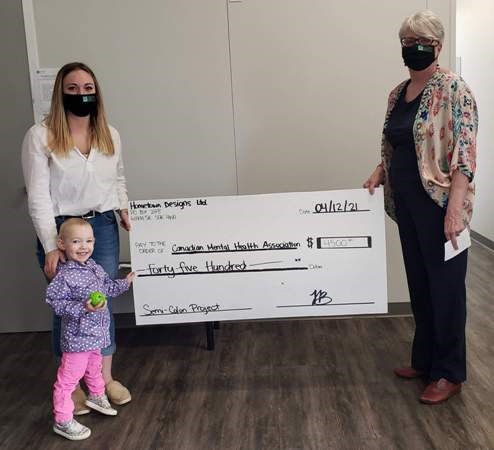 Toni Bryan, owner of Hometown Designs, along with daughter Spencer presents the proceeds of her Cont;nue fundraiser to the Canadian Mental Health Association.