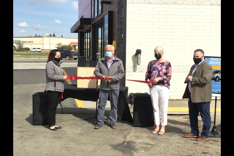 The ribbon is cut at the grand re-opening of the Territorial gas bar and convenience store. Seen from left to right are Jenn Szito (site manager), Dave Rogers (C-store division manager), Rosalie Payne (board president) and Mike Nord (Discovery Co-op general manager). Photo by John Cairns