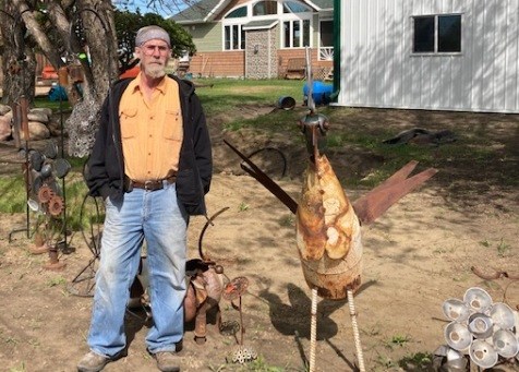 Geordie Smith, longtime resident of Ruddell, with a lawn ornament crafted from discarded metal items. Smith offers blacksmith lessons for people who want to learn this old craft. Photos by Elaine Woloshyn